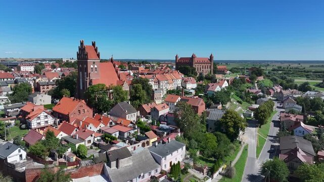 Aerial Gniew Poland historic brick castle and church fast. Northern Poland. Castle construction 13th century by Teutonic Knights. Vistula River. Agriculture land, river, forest and farm rural area.