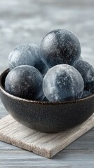 Frozen spheres in dark bowl on light wood