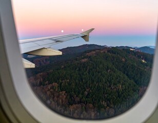 Airplane window view of mountains and sunset