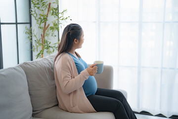 Pregnant asian woman drinking milk at home relaxation and Self-care  Pregnancy drinking a glass of...