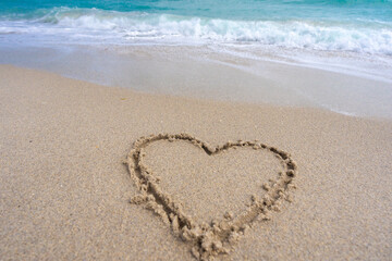 Ocean waves background. Tropical ocean waves. Blue seaside view. Heart drawn in sand. Waves forming a heart shape sign. Love on beach. Romantic summer. Heart made of sand. Love and ocean waves.