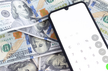 Teléfono móvil con aplicación de calculadora abierta sobre dólares. Transacción y operación financiera. 