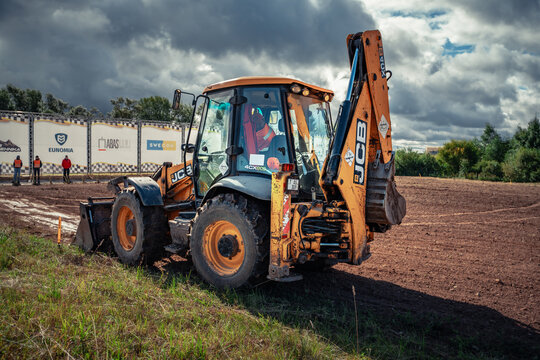 Latvia, Kandava, 2025-08-23, Latvijas kauss A JCB excavator at work on a rugged terrain under a dramatic sky
