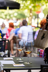 Pair of Wine Glasses on a Busy Summer Patio at an Outdoor Winery Tasting