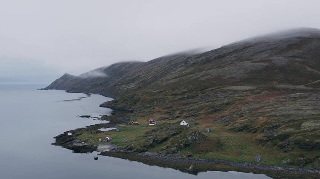 Raw and serene beauty of a remote fjord, surrounding mountains under a misty sky