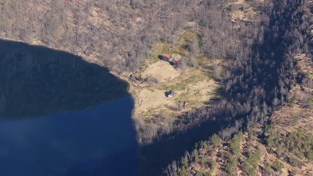 Drone flying over the mountain farm called Kringlebotn, surrounded by the rugged Matrefjellene mountains in spring