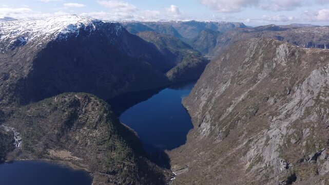 Cinematic aerial footage gliding over Matrefjellene mountains, capturing rugged peaks, snow, and springtime alpine beauty.