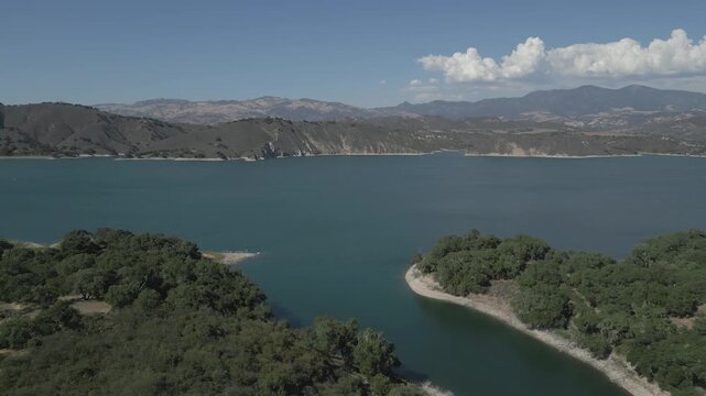 The Cachuma Lake water reservoir in California is shown from an aerial flyby view on a beautiful, summer day.