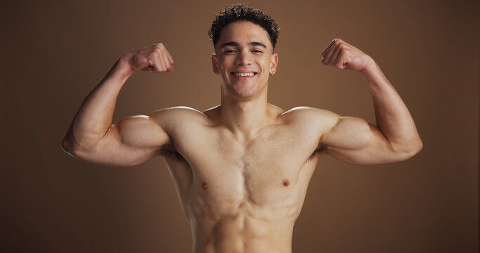 Portrait, man and flexing arms in studio background for exercise, fitness process and training results. Male person, bodybuilder and shirtless for strong muscles, bicep power and confidence of growth