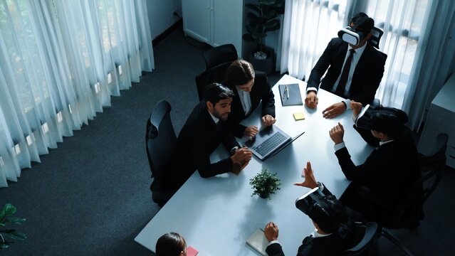 Top view of manager working on laptop and sending data analysis to business people by using VR glass headset while diverse team moving gesture while working together to planning idea. Directorate.