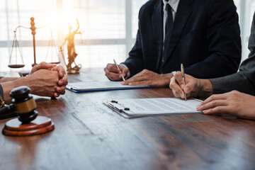 Business professionals engaged in signing a contract while collaborating with lawyers in a modern office setting, finalizing an important deal