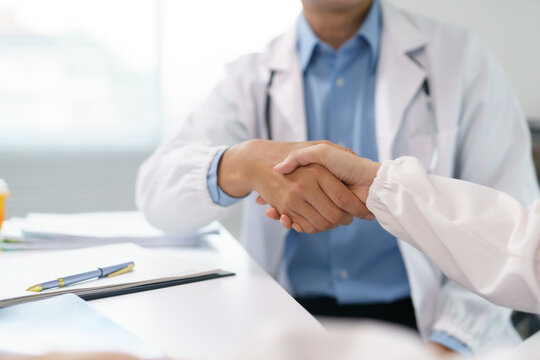 Two doctors shaking hands after reaching an agreement during a medical meeting, fostering collaboration and trust in healthcare