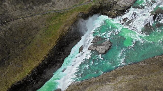 Close aerial drone view of Gullfoss waterfall in Iceland. 4K cinematic footage of powerful whitewater in volcanic canyon.