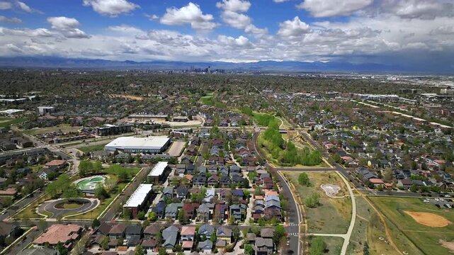 Front Range Denver Lowry Northfield Central Park neighborhood apartment buildings Colorado aerial drone sunny cloudy sky cloudy Lakewood Arvada Golden cars cityscape skyscrapers forward pan up motion