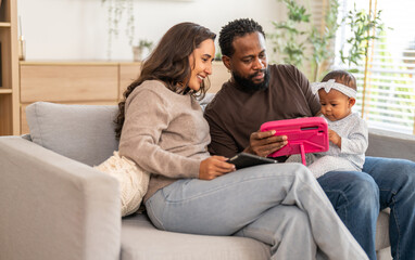 Obraz premium African love family happy time at home, father showing baby a tablet with cartoons for early childhood learning and development, mother smiling engaging in digital parenting and interactive education