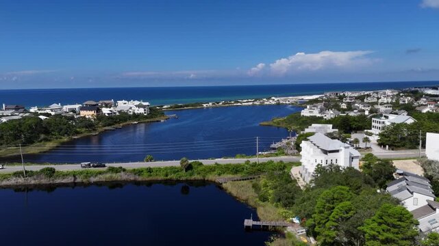 Aerial fly over coastal Camp Creek Lake with houses with connection between banks, 30A, Florida, USA