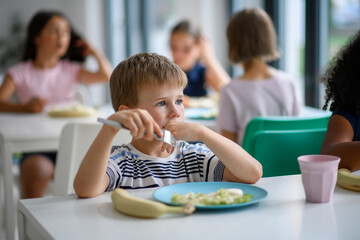 Fototapeta premium Kids in school eating in canteen, having healthy lunch.