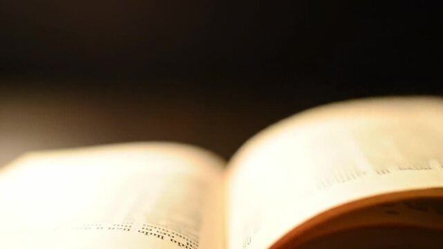 Close up of open book pages flipping showing texture and education