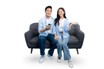 A cheerful couple on a comfortable gray sofa holding a phone and smiling against a clean background. The scene captures the modern lifestyle and ease of communication.