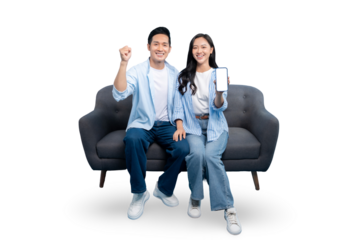 A smiling couple sitting on a comfortable sofa, holding a smartphone, ready to shop. With white background
