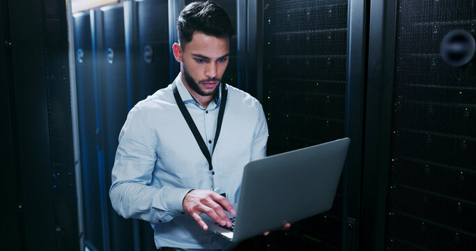 Data center, cybersecurity and man with laptop, typing and network engineer with tech for software. Server room, IT specialist and person with computer for firmware upgrade, serious and maintenance