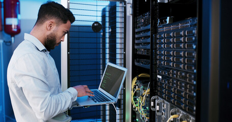 Man, laptop and typing for inspection in server room, hardware and programming for IT solution at company. Person, cybersecurity and assessment with computer, coding and update software for system