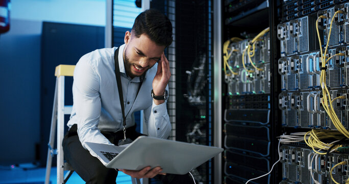 Frustrated man, headache or stress with laptop in server room for network failure or system error. Male person, IT technician or mistake with anxiety on computer for security fault or troubleshooting