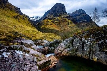 Obraz premium River Coe flows through Glen Coe with The Three Sisters mountains in early spring, Scotland