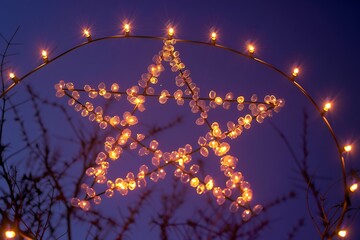 Twinkling star lights illuminate a twilight sky, creating magical festive ambiance for holidays and celebrations.