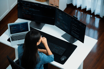 Top view young Asian IT developer creating with typing online information on pc with coding program data of website application, wearing jeans shirt. surround by safety analysis two screen. Stratagem.