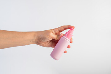 Pink product bottle in hand on white background