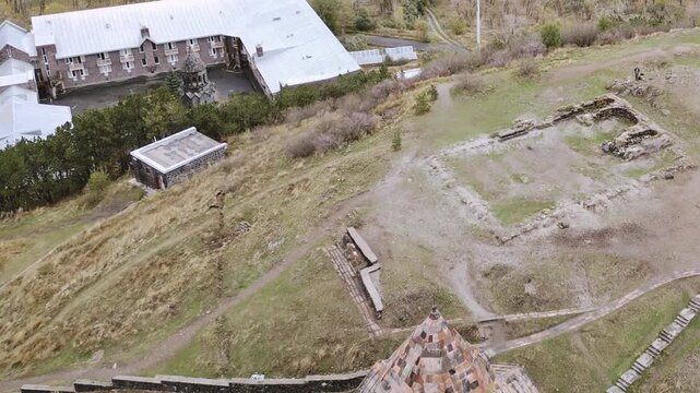 Aerial birds eye view of the Sevanavank Monastery and chapel overlooking famous Sevan lake at cloudy day. Tourist group visit.Travel and tourist destinations of Armenia