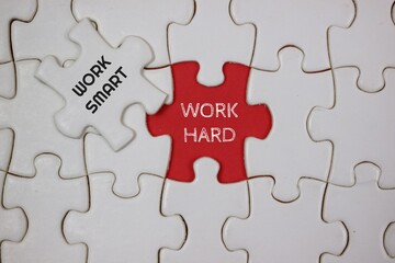 Fototapeta premium Conceptual Puzzle Representing Hard Work and Smart Work Techniques, highlighted in red and white puzzle
