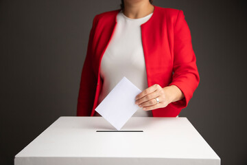 The voter holds his vote ballot paper and places it in the ballot box. Election concept.