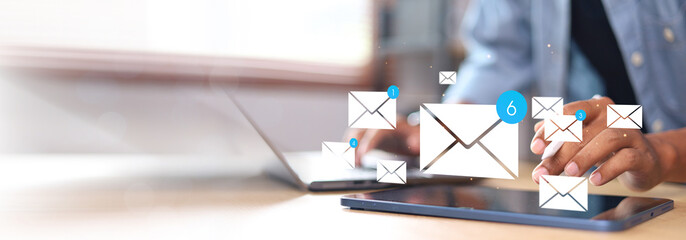 Person checking smartphone with email icons floating above. Concept of digital communication, mobile inbox, real-time notification, and online message system.