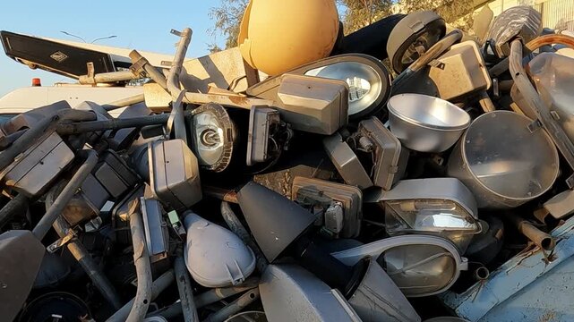 Tracking footage follows a lot of old technology street lamps inside a skip bin, ready to go for recycling .