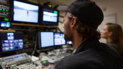 Focused technicians operate complex video equipment, creating a dynamic control room atmosphere, evoking teamwork during a live broadcast event