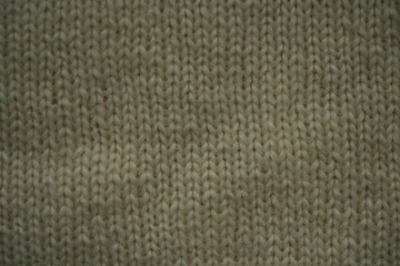 Knitted fabric texture in gray olive color. Close-up of soft textile surface with detailed yarn pattern — perfect background for fashion, craft, or design.
