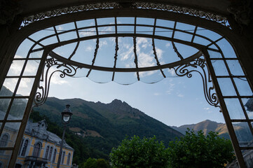 Fototapeta premium Historical architecture in Cauteret highlights its charm against the backdrop of majestic mountains, creating a picturesque view during a calm afternoon.