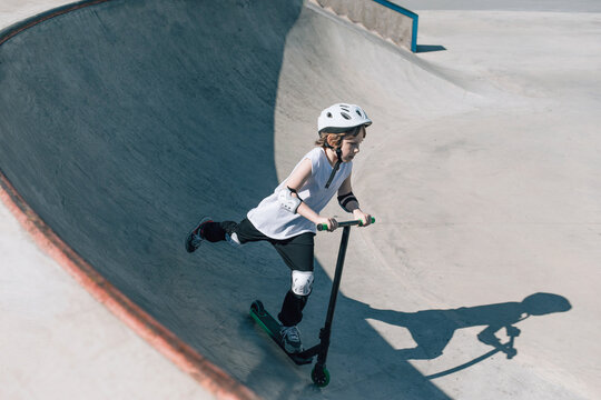 Scooter Rider Skillfully Performing Tricks in Skatepark Setting
