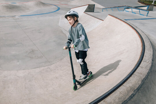 Young boy scooter at concrete skatepark