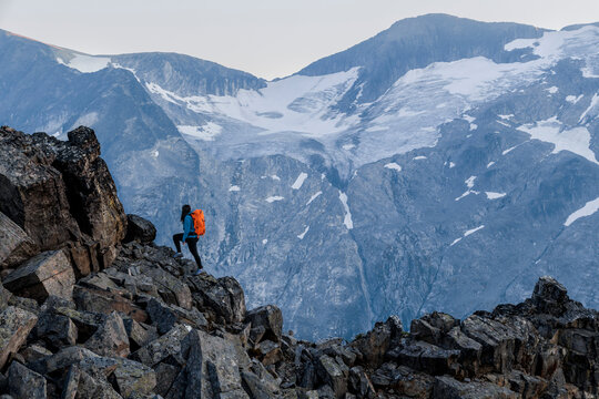 Female backpacker on the move, hiking over rocky terrain, Canada.