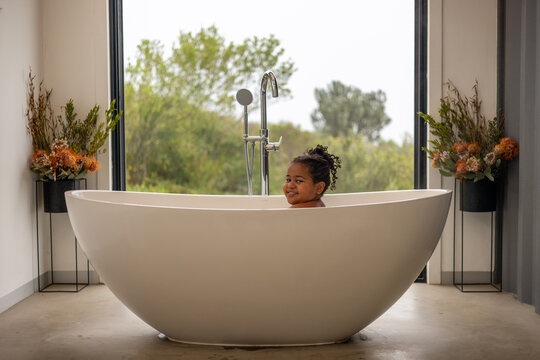 A young girl smiling in the bath tub