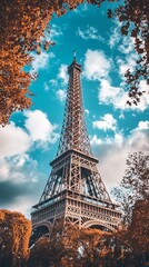 Eiffel Tower framed by autumnal trees under a vibrant sky