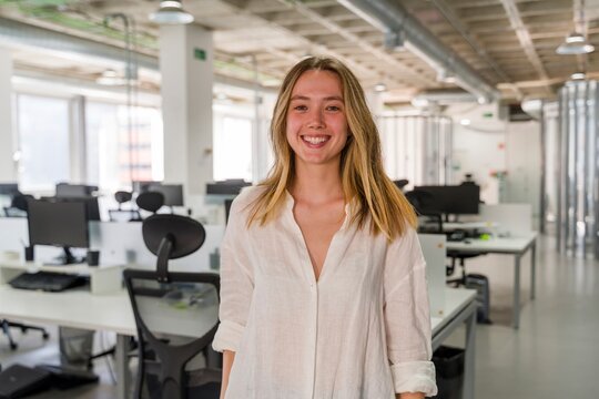 Smiling businessperson in modern office workspace during workday