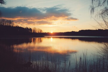 Fototapeta premium Serene sunset over a calm lake, silhouetted trees