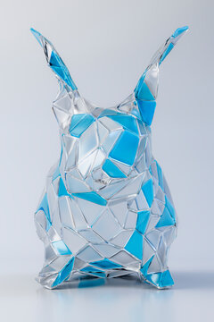 Geometric glass rabbit sculpture with blue accents in studio