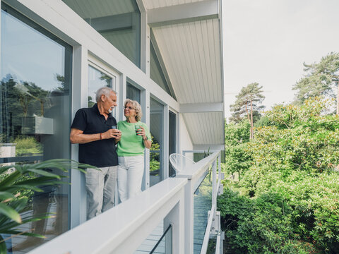 Couple enjoying leisure time on modern balcony in summer