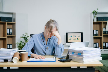 woman feeling migraine head strain.Overworked businesswoman financier while working on laptop and tablet at office.