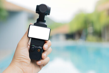 Close up picture of black pocket camera with blank screen on woman hand holding.